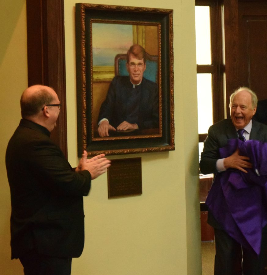 SHC President Dr. Christopher Puto, right, and Fr. Mark Mossa, S.J., at left, react at the unveiling of a portrait of the Rev. William J. Rewak S.J. The unveiling celebrated the naming of the Rotunda in honor of Rev. Rewak.