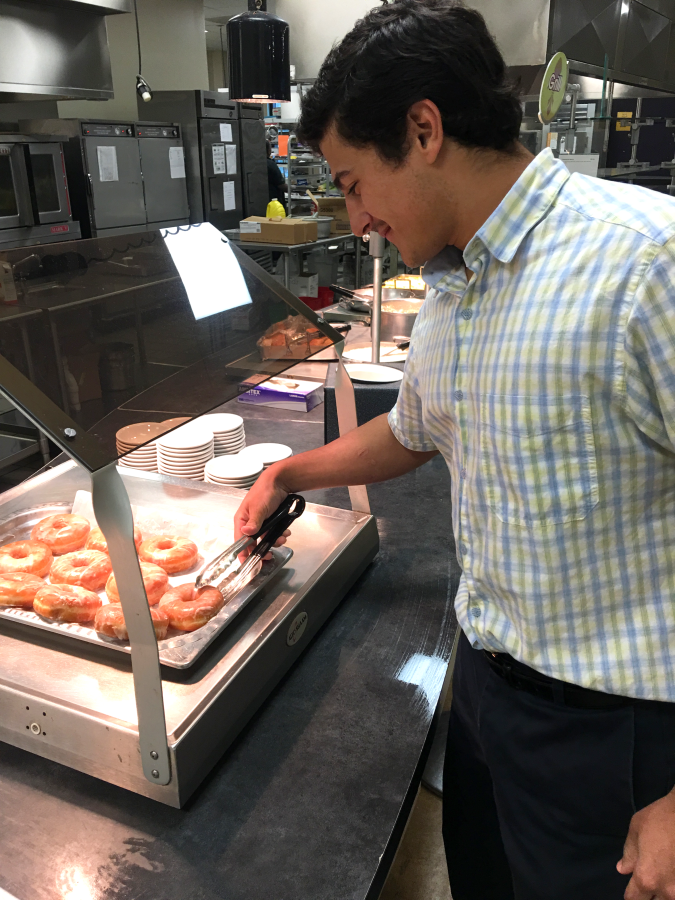 Junior Tempel Viti checks out the fresh donuts in the cafeteria.