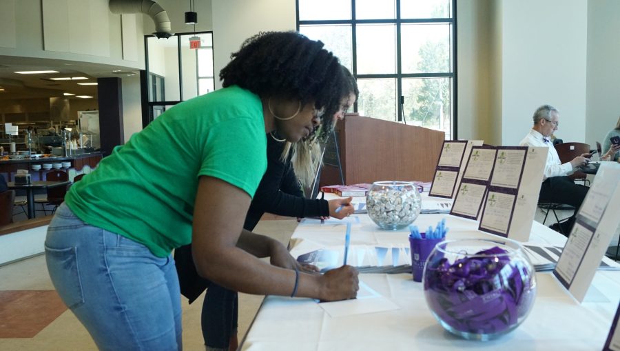 Students sign up at the Give Day table in the cafeteria. 