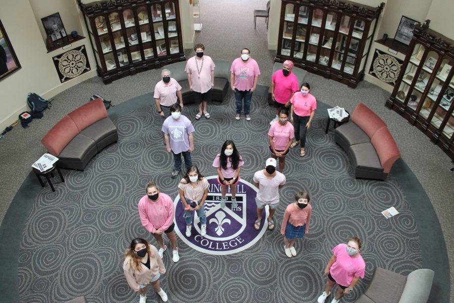 SHC Students wearing pink shirts stand in the shape of the cancer ribbon. 