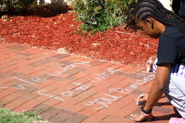 Vice President of BSU Madison Colvin writing chalk in remembrance of the racist incident that took place a year ago.