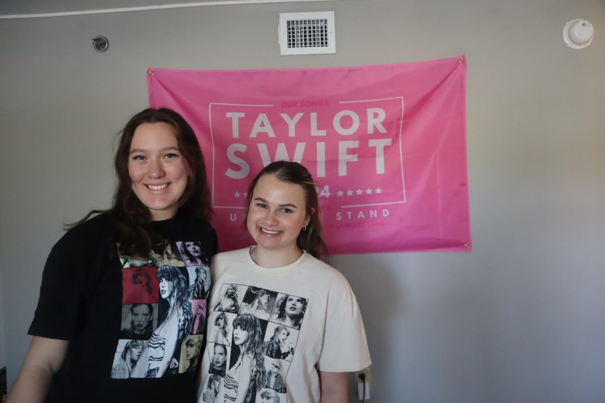 Juniors Allie Berg and Cassidy Granger repping their Eras Tour t-shirts and Taylor Swift flag. 